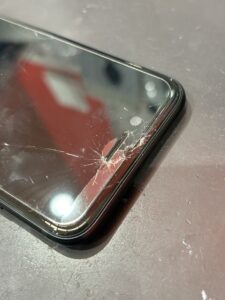 iPhone SE第3世代のフロントガラスが右上から大きく割れている状態の写真。川口市の修理依頼