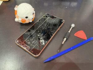 画面が大きく割れたAQUOS Sense3と修理工具の写真（川口市にて修理対応）