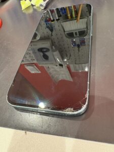 角から大きく割れたiPhone16のフロントガラスの状態
