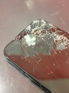 画面左上付近を中心に大きく割れたiPhone16。ガラス割れが広範囲に広がっている修理前の状態。